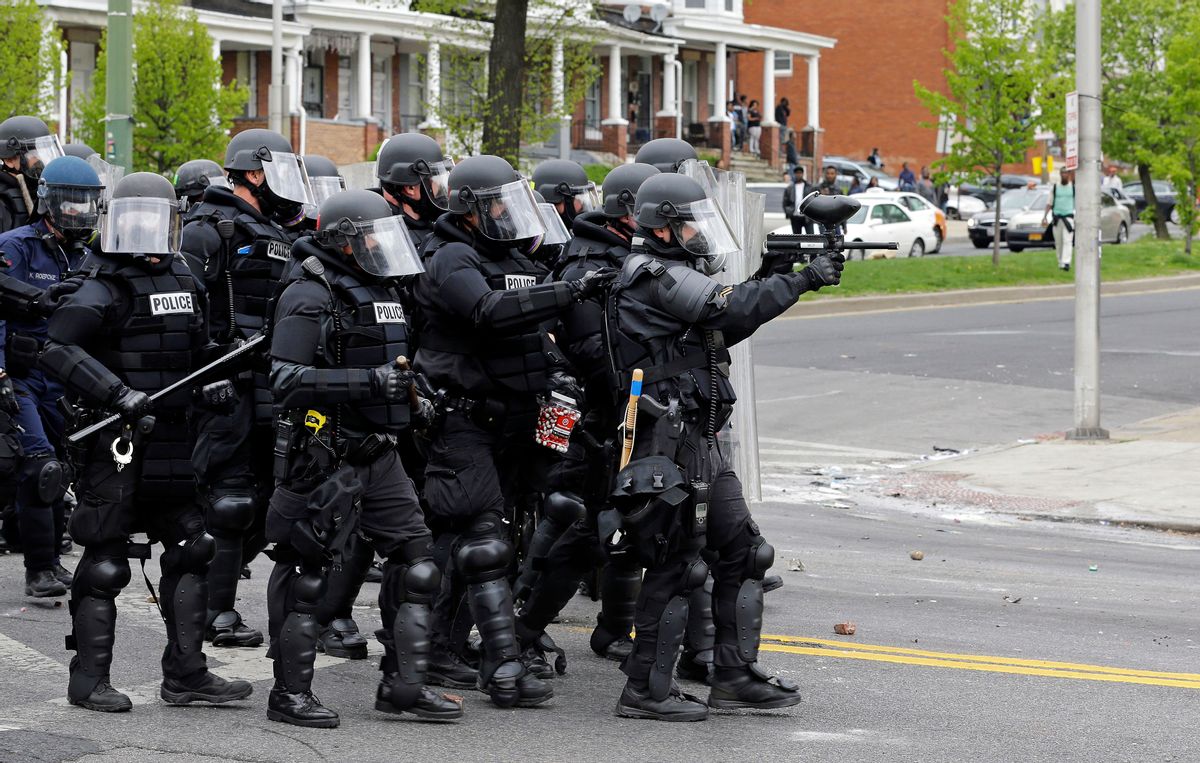 Police move down a street in response to demonstrators who were throwing objects, Monday, April 27, 2015, after the funeral of Freddie Gray in Baltimore. Gray died from spinal injuries about a week after he was arrested and transported in a Baltimore Police Department van.  (AP/Patrick Semansky)