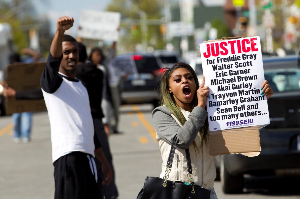 Caira Byrd hold support signs for Freddie Gray outside of Vaughn Greene Funeral Home, during his wake in Baltimore, Md., Sunday, April 26, 2015. Gray died from spinal injuries about a week after he was arrested and transported in a police van.  (AP/Jose Luis Magana)