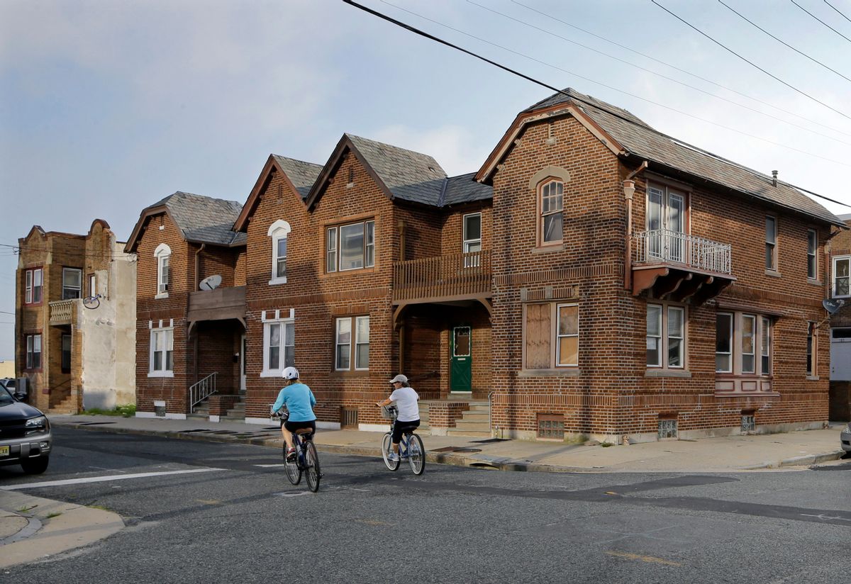 FILE  In this Wednesday, July 23, 2014 file photograph, a pair of bicyclists pedal past older attached homes, some with boarded windows on the north end of Atlantic City, N.J. A loan program that was supposed to lend as much as $40 million to struggling homeowners and businesses in this cash-strapped resort city has given out nothing and instead led to a federal lawsuit. Atlantic City is suing to get back $3 million it gave to the company that has failed to run the Community Loan Program, launched in 2013 by Lorenzo Langford, the mayor at the time.  (AP Photo/Mel Evans,file)