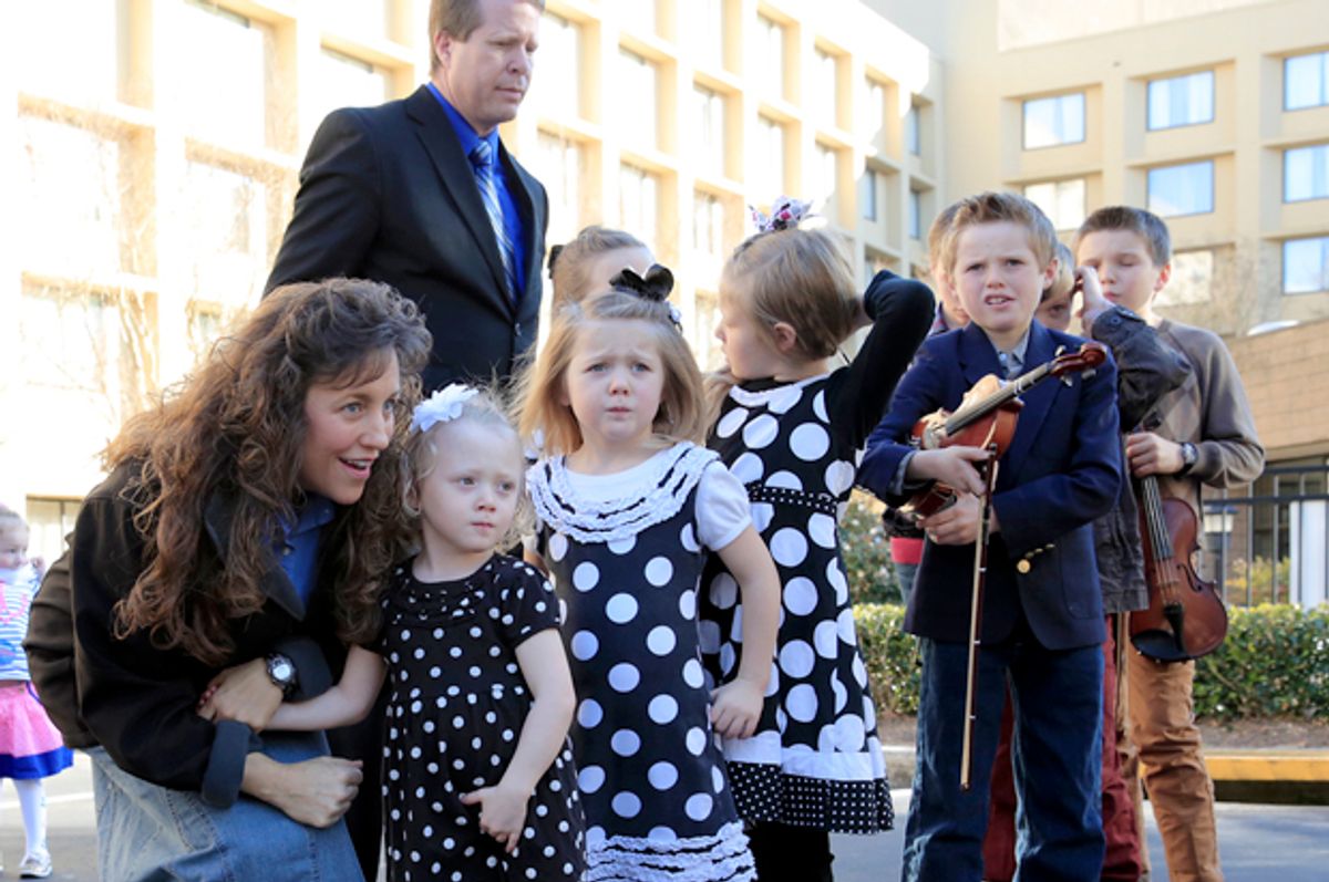 Michelle Duggar, kneeling, and Jim Bob Duggar, back right, and many of the Duggar's 19 children, in Raleigh, N.C., March 14, 2014.                   (AP/Ted Richardson)