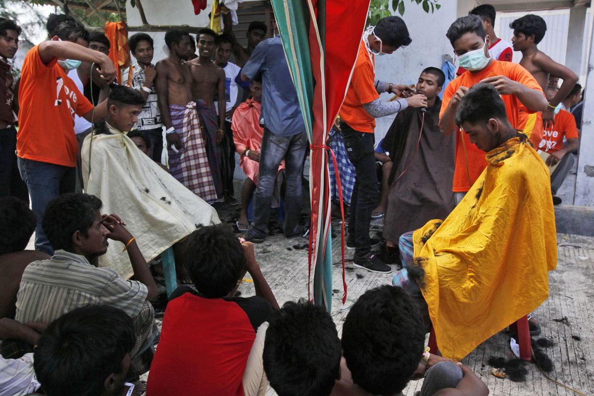 Ethnic Rohingya men take free haircut service provided by a local NGO at a temporary shelter in Langsa, Aceh province, Indonesia, Tuesday, May 19, 2015.  Indonesia has "given more than it should" to help hundreds of Rohingya and Bangladeshi migrants stranded on boats by human traffickers, its foreign minister said Tuesday, a day before she was to meet with her counterparts from the other countries feeling the brunt of the humanitarian crisis. (AP Photo/Binsar Bakkara) (Binsar Bakkara)