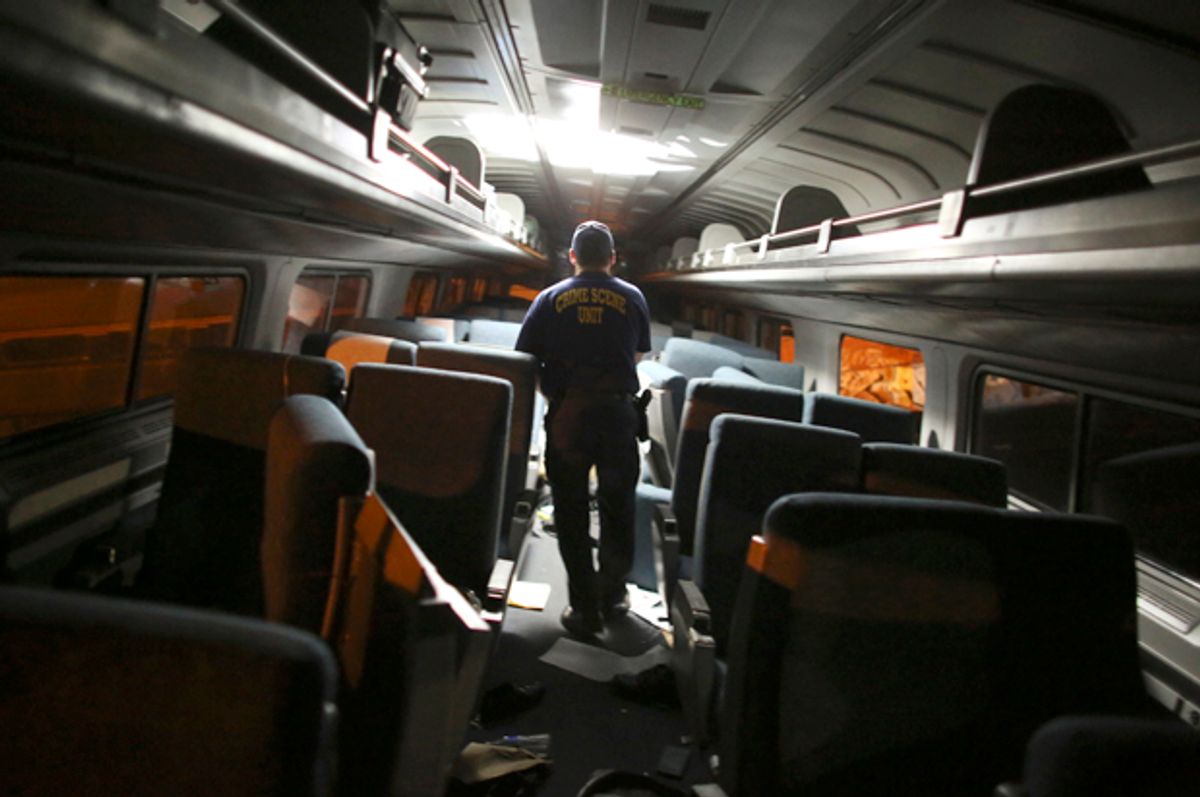 A crime scene investigator looks inside a train car after a train wreck, Tuesday, May 12, 2015, in Philadelphia.        (AP/Joseph Kaczmarek)