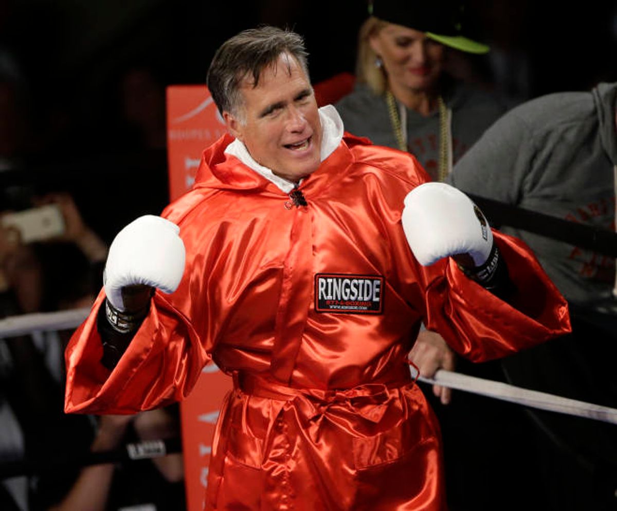 Former Republican presidential candidate Mitt Romney raises his gloves before sparring with five-time heavyweight boxing champion Evander Holyfield during a charity fight night event  (AP Photo/Rick Bowmer)