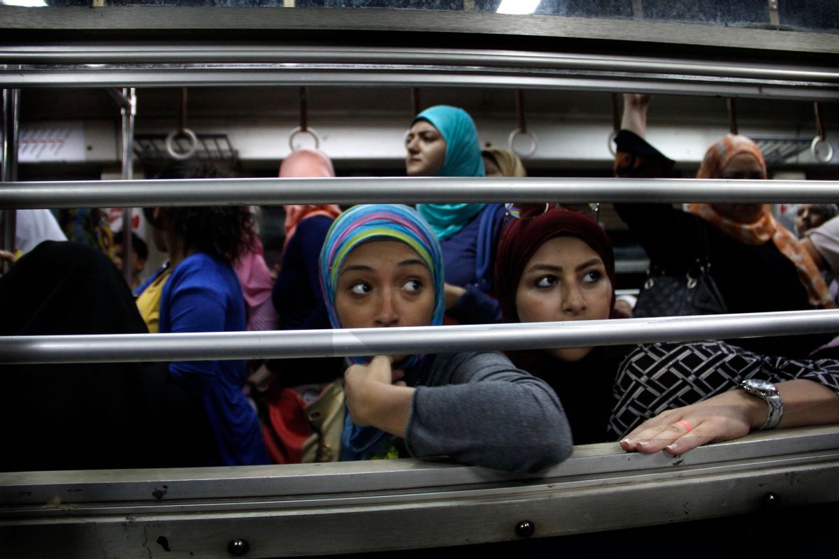 In this Sept. 13, 2014 photo, Egyptian women look from an all-female car at the Shohadaa (Martyrs) metro station in Cairo, Egypt. Before the 2011 Egyptian revolution the station was named for former President Hosni Mubarak. In a city known, as much as anything, for its dysfunction, the Cairo Metro stands as a singular achievement. It's reliable, well-maintained and relatively clean. (AP Photo/Heba Elkholy) (AP)