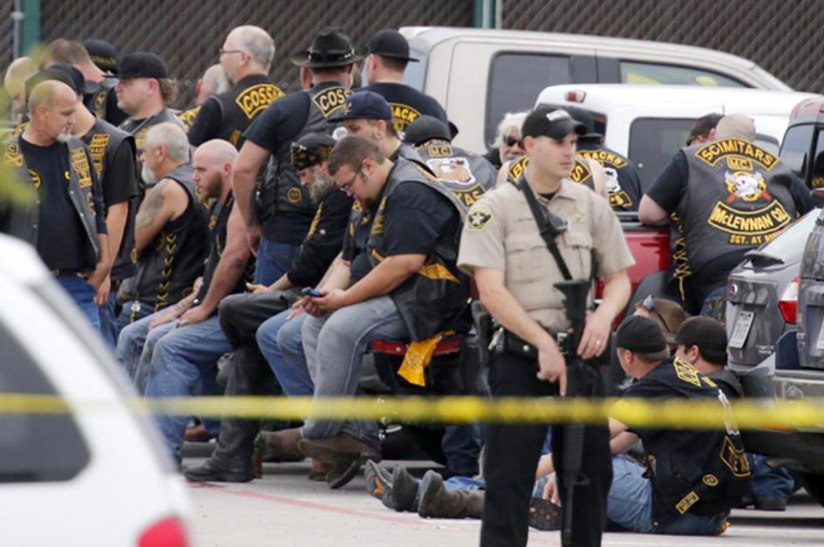 A McLennan County deputy stands guard near a group of bikers in the parking lot of a Twin Peaks restaurant, May 17, 2015, in Waco, Texas.  (AP/Rod Aydelotte)