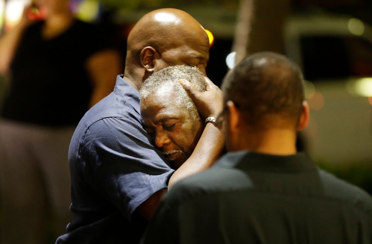 Worshippers embrace following a group prayer across the street from the scene of a shooting Wednesday, June 17, 2015, in Charleston, S.C. (AP Photo/David Goldman)  (AP)