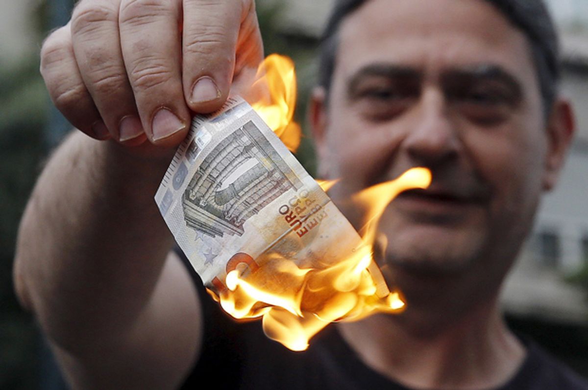 Anti-austerity protesters burn a euro note during a demonstration outside the European Union (EU) offices in Athens, Greece June 28, 2015.     (Reuters/Alkis Konstantinidis)