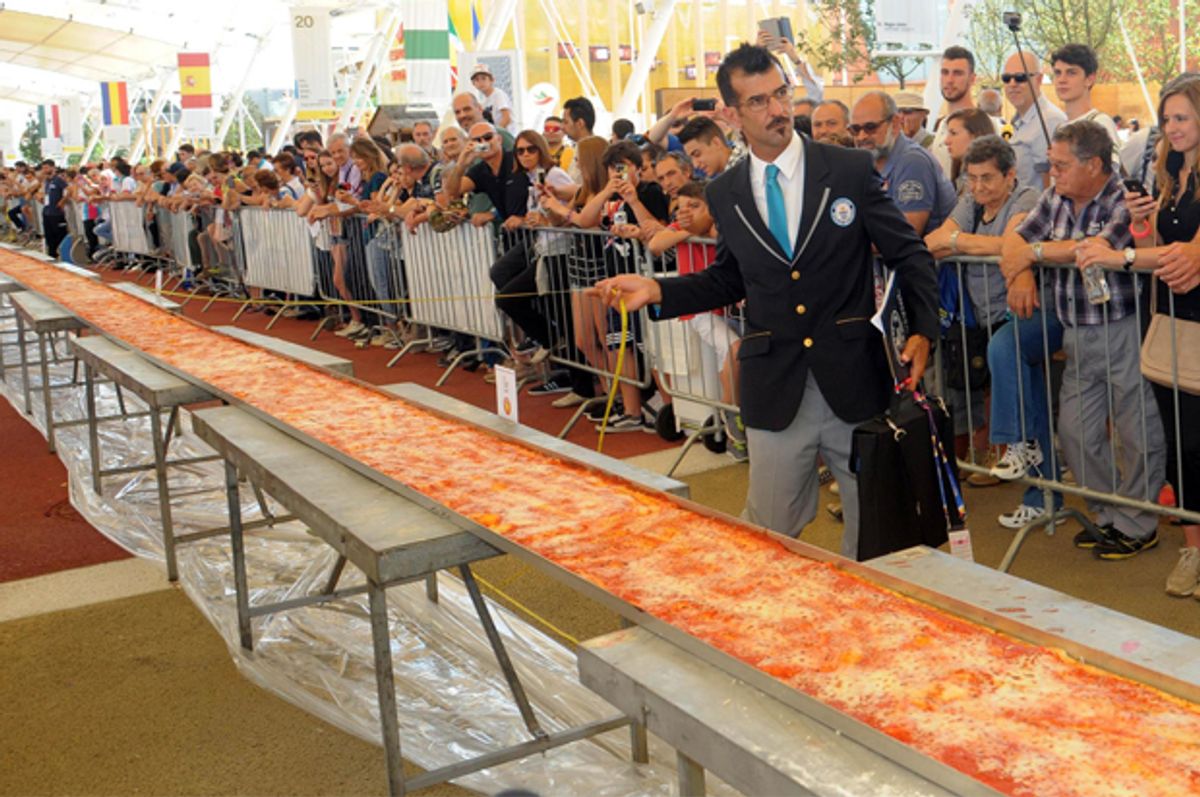 Judge of the Guinness World Records Lorenzo Veltri checks the length of a pizza at the Expo 2015 world's fair in Rho, near Milan, June 20, 2015.          (AP/Daniele Mascolo)