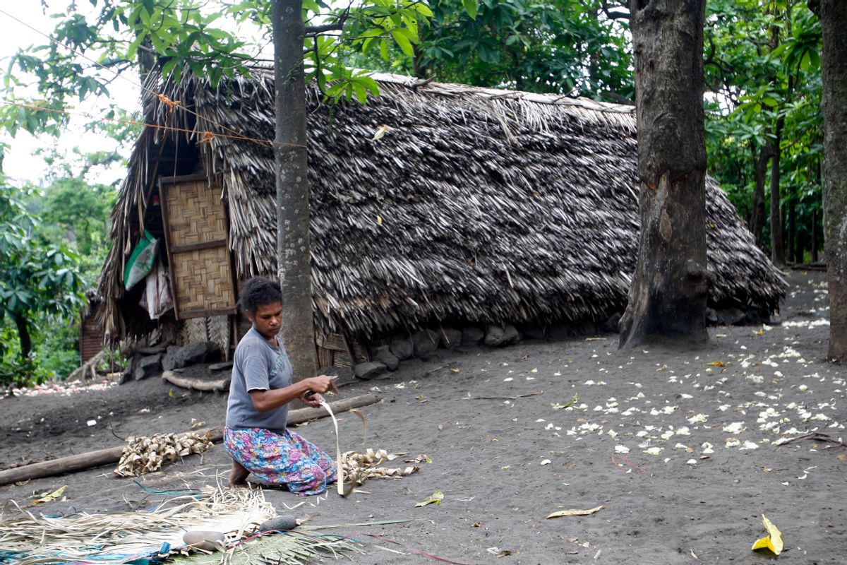 A woman weaves a mat in a village on Tanna Island in Vanuatu on Tuesday, June 2, 2015. Tanna Island was particularly hard hit by Cyclone Pam, which struck in March. Many people in Vanuatu believe the cyclone was the latest manifestation of climate change. (AP Photo/Nick Perry) (Nick Perry)