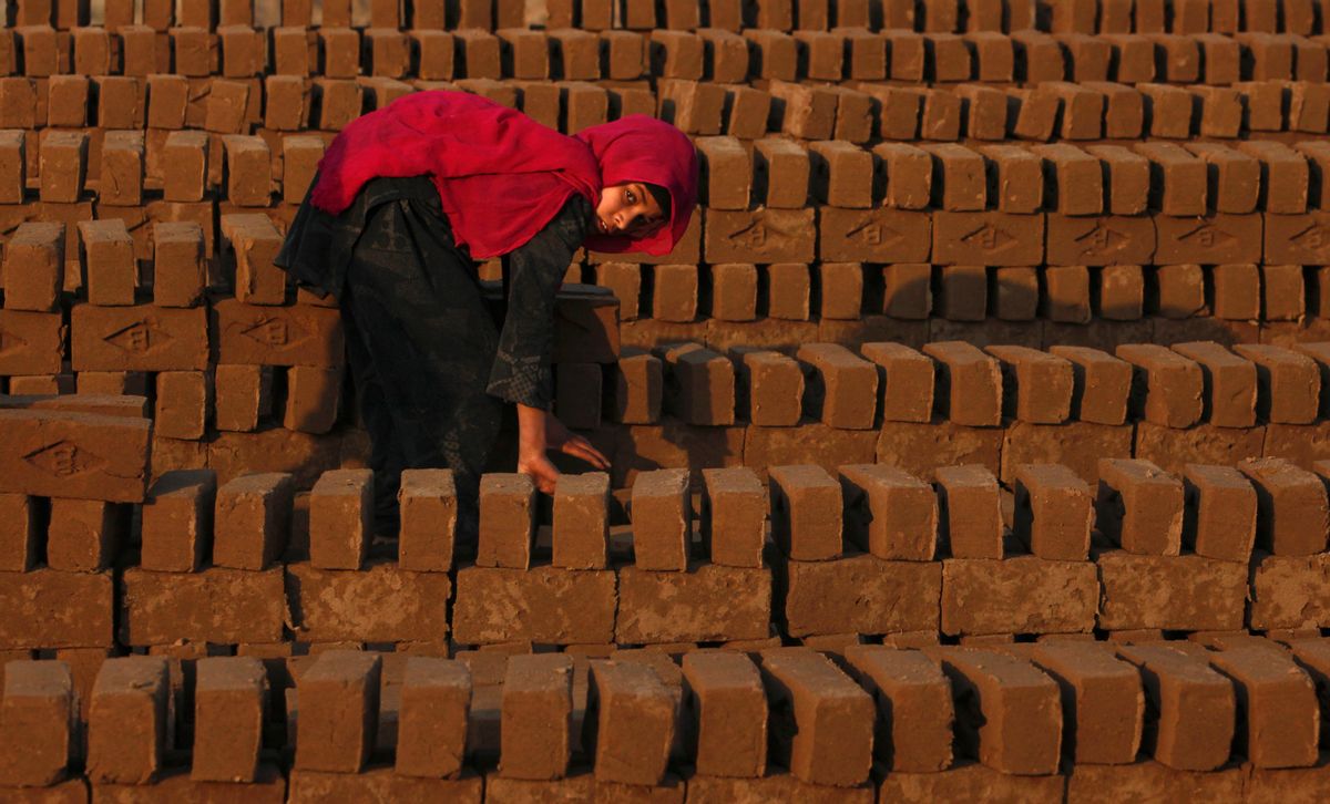 Farzeena, 12, arranges bricks to be baked in a kiln at a brickyard in the outskirts of Islamabad December 28, 2011. REUTERS/Faisal Mahmood  (PAKISTAN - Tags: BUSINESS EMPLOYMENT ENVIRONMENT) - RTR2VOPK (REUTERS/Faisal Mahmood)
