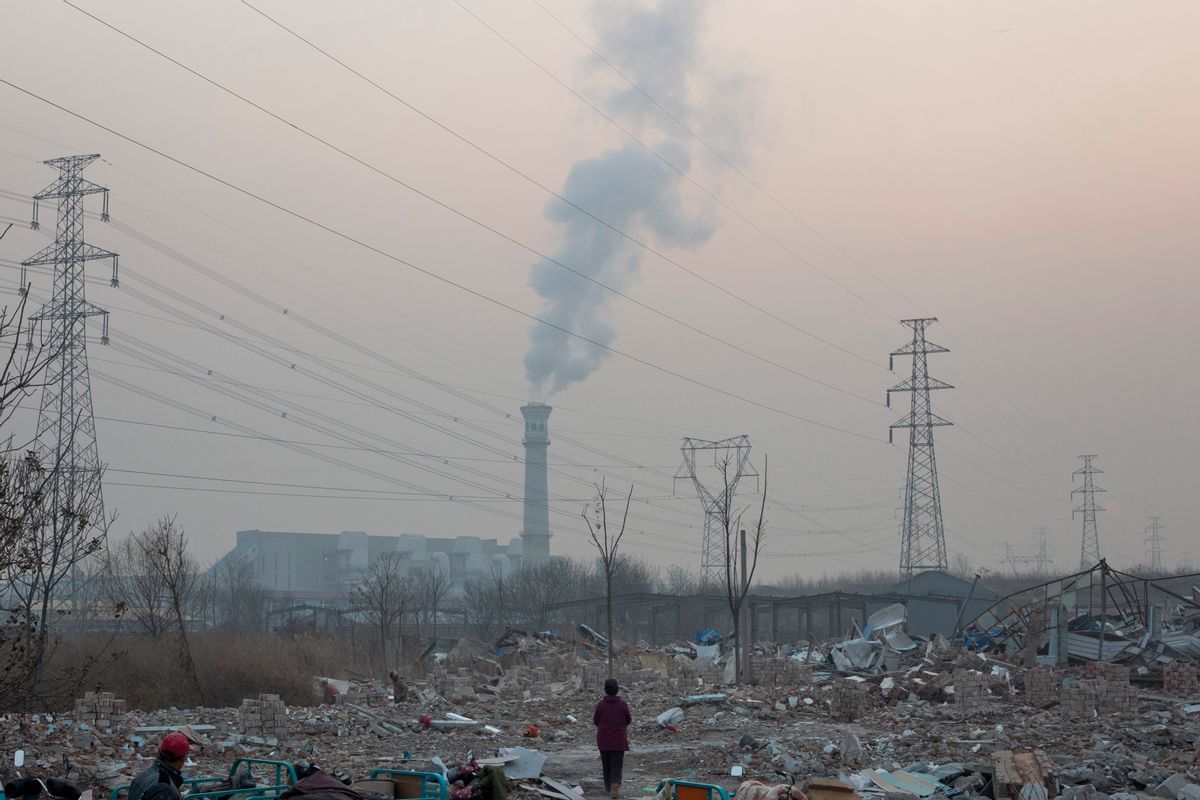 In this photo taken Saturday, Dec. 12, 2015, a scrap collector salvages material from a demolished neighborhood near a chimney spewing smoke in Beijing, China.  China's push for a global climate pact was partly because of its own increasingly pressing need to solve serious environmental problems, observers said Sunday. (AP Photo/Ng Han Guan) (AP)