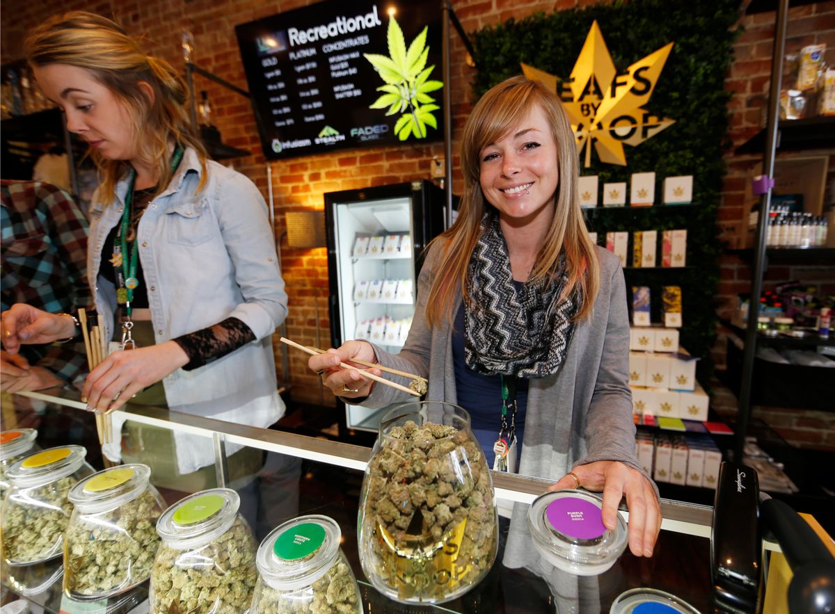 In this Friday, Dec. 18, 2015, photograph, LivWell store manager Carlyssa Scanlon shows off some of the products available in the marijuana line marketed by rapper Snoop Dogg in one of the marijuana chain's outlets south of downtown Denver. LivWell grows the Snoop pot alongside many other strains on its menu. (AP Photo/David Zalubowski) (AP)