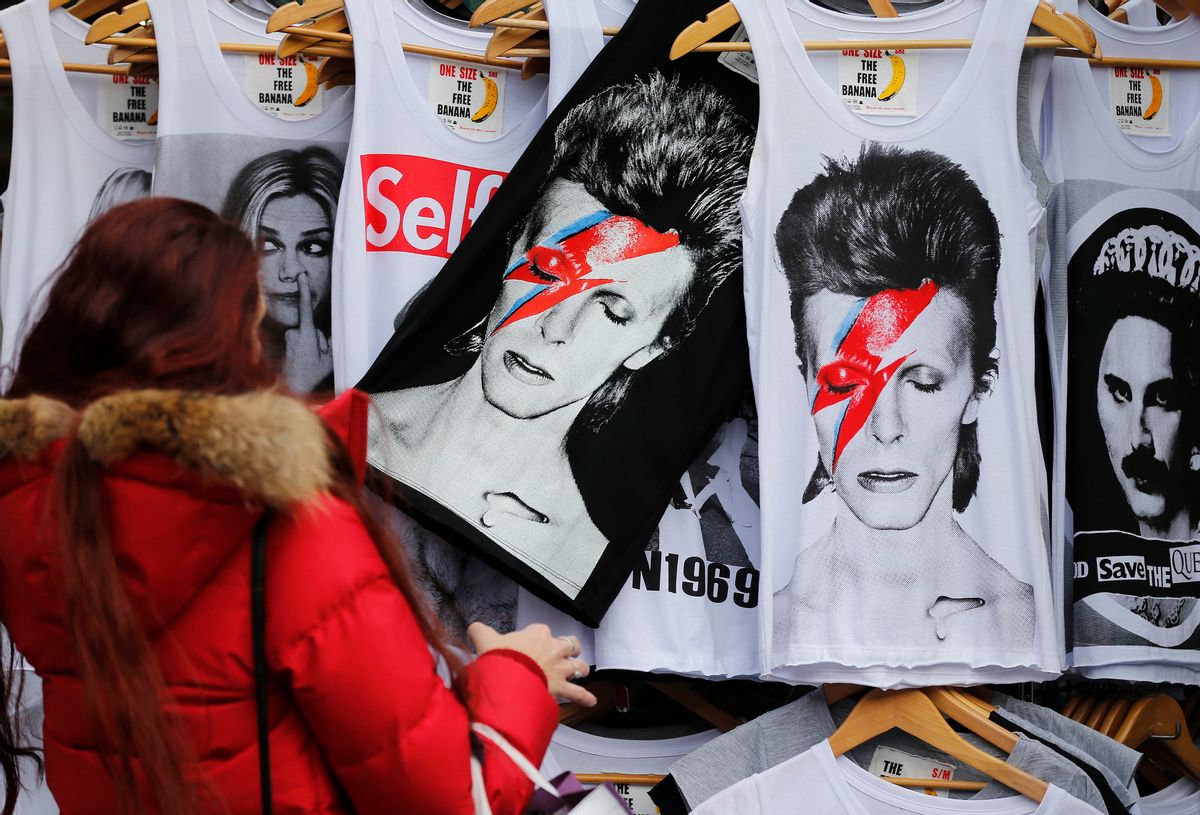 A woman looks at shirts with a portrait of David Bowie, in London, Monday, Jan. 11, 2016. David Bowie, the other-worldly musician who broke pop and rock boundaries with creative musicianship, nonconformity, striking visuals and a genre-bending persona and christened Ziggy Stardust, died of cancer Sunday. He was 69 and had just released a new album.(AP Photo/Frank Augstein) (AP)