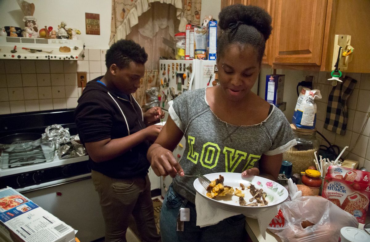 In this Friday, May 22, 2015 photo, Candie Hailey, right, and Timothy, her best friend's brother, eat leftovers while visiting her father's Bronx apartment in New York. For a while after her release from Rikers Island jail, where she spent 2 1/3 years in solitary during her more than three-year incarceration, her father's cooking was a welcomed treat until her struggle to recover from the trauma of confinement caused an estrangement. (AP Photo/Bebeto Matthews) (AP)