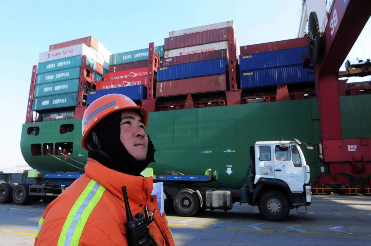 A port worker stands near a container ship at a port in Qingdao in eastern China's Shandong province Monday Feb. 15, 2016.  (Chinatopix Via APCHINA OUT)
