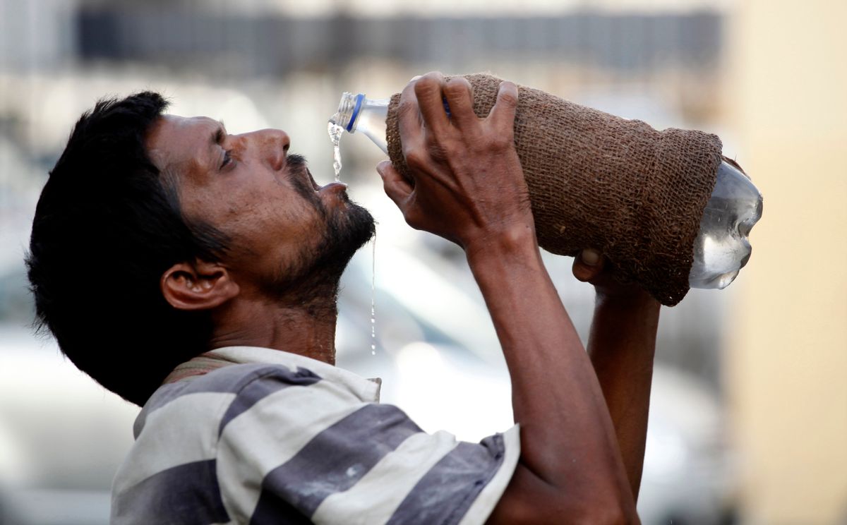 FILE - In this Sunday, May 31, 2015, file photo, an Indian drinks water from a bottle on a hot summer day in Allahabad, India. India is launching programs to protect people from extreme heat in two high-risk cities, after a devastating heat wave killed at least 2,500 people across the country last year. (AP/Rajesh Kumar Singh, file)
