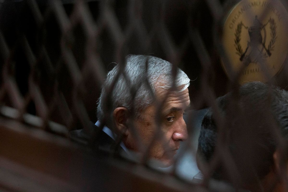 FILE - In this Sept. 8, 2015 file photo, Guatemala's former President Otto Perez Molina, photographed through a window, sits in court for a third hearing on corruption allegations that led him to resign, in Guatemala City.  (AP Photo/Esteban Felix, File))