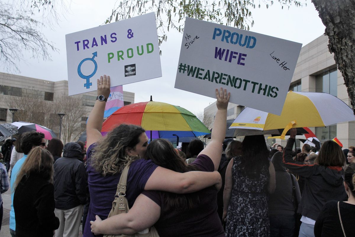 Two protesters hold up signs against passage of legislation in North Carolina, which limits the bathroom options for transgender people, during a rally in Charlotte, N.C., Thursday, March 31, 2016. The rally drew around 100 people at the Charlotte-Mecklenburg Government Center. (AP Photos/Skip Foreman) (AP)