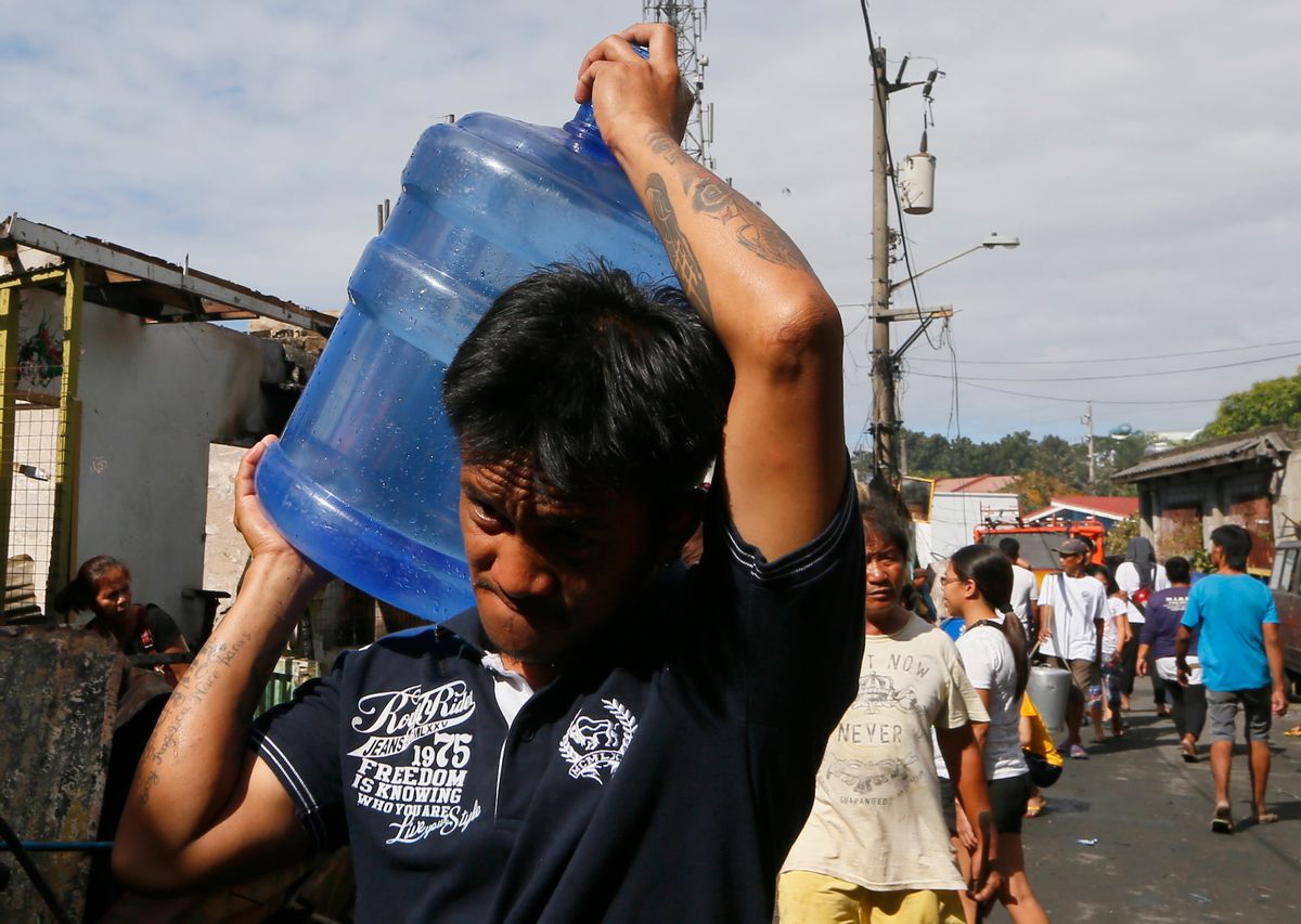 In this Feb. 23, 2016 photo, a resident carries drinking water following an overnight fire at a poor neighborhood in Muntinlupa city southeast of Manila, Philippines. Water was not supposed to become so expensive for Manila under a 1997 World Bank deal that privatized the seaside citys water and sewage management. That arrangement is under fire by the U.S. congressional committee that oversees the international development bank, which is now questioning whether the World Bank and its lending arm, the International Finance Corp., should join in such "public-private partnerships."  (AP Photo/Bullit Marquez) (AP)