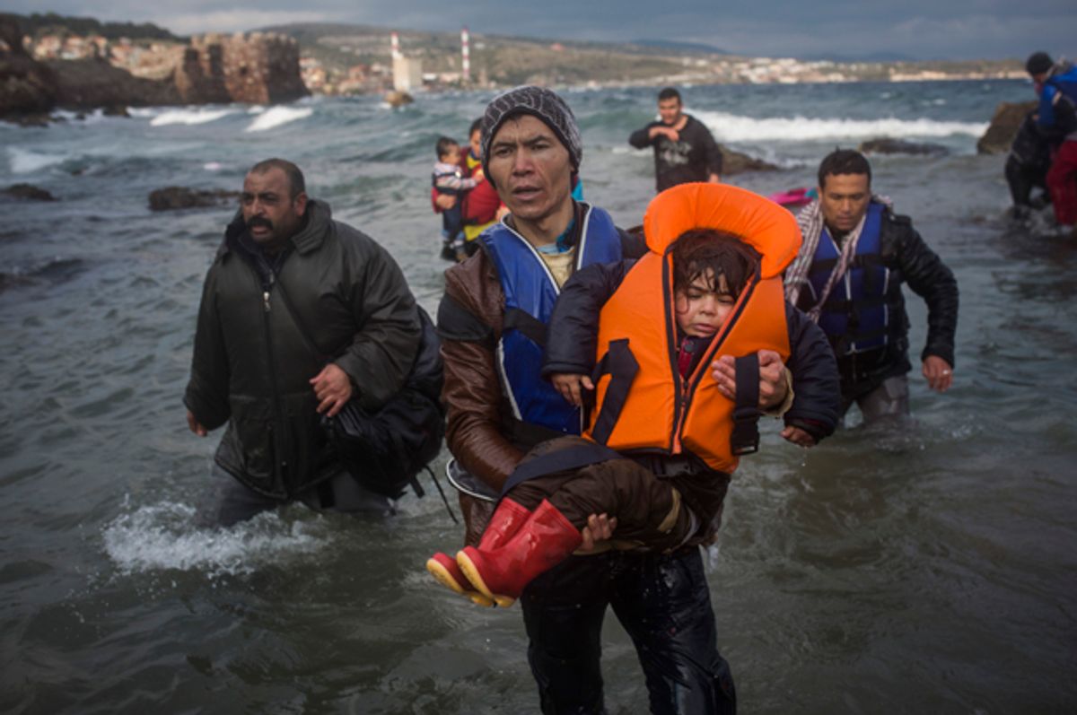 Refugees and migrants make their way out of the Aegean Sea on the Greek island of Lesbos, Dec. 12, 2015.   (AP/Santi Palacios)