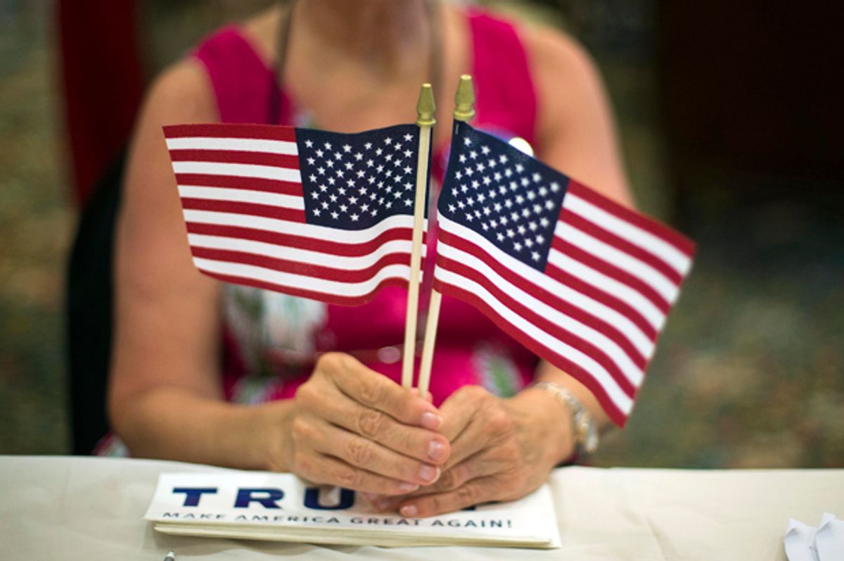 A volunteer hands out flags at a Donald Trump Rally in Bluffton, S.C., July 21, 2015.    (AP/Stephen B. Morton)