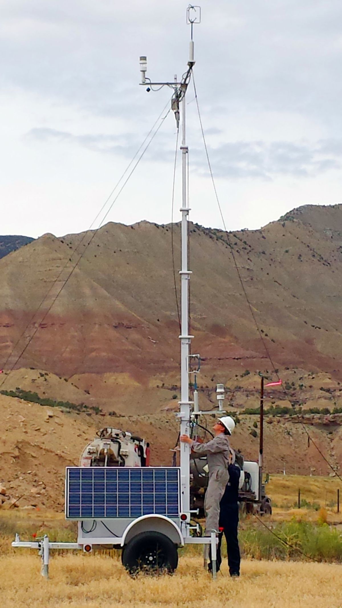 In this 2014 photo provided by Colorado State University, CSU research associate Kira Shonkwiler, front, and student Landan MacDonald, standing behind Shonkwiler, set up a weather station in Garfield County, Colo., as part of a study on air pollution from fracking wells.  (AP)