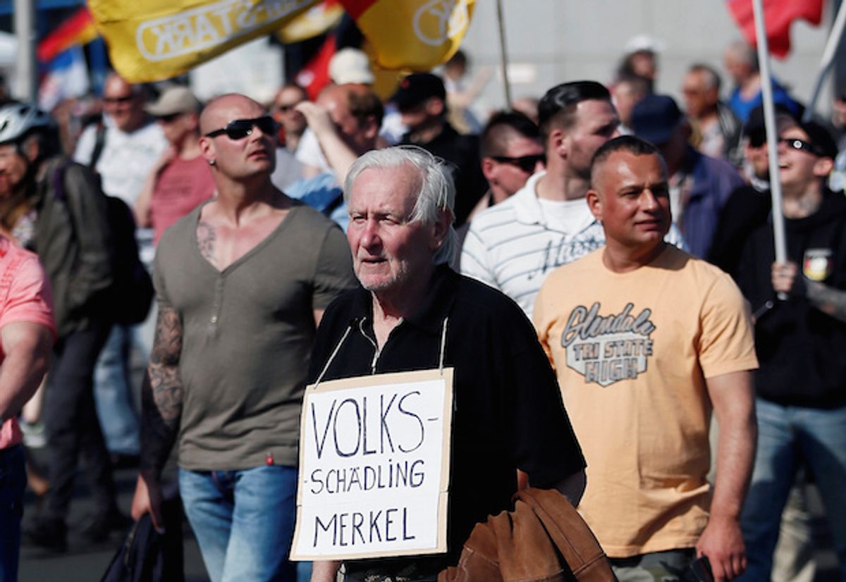 A German man holds a sign with the Nazi propaganda term "Volksschädling" (enemy of the people) at a right-wing protest against refugees, Islam and Chancellor Angela Merkel in Berlin, Germany on May 7, 2016  (Reuters/Hannibal Hanschke)