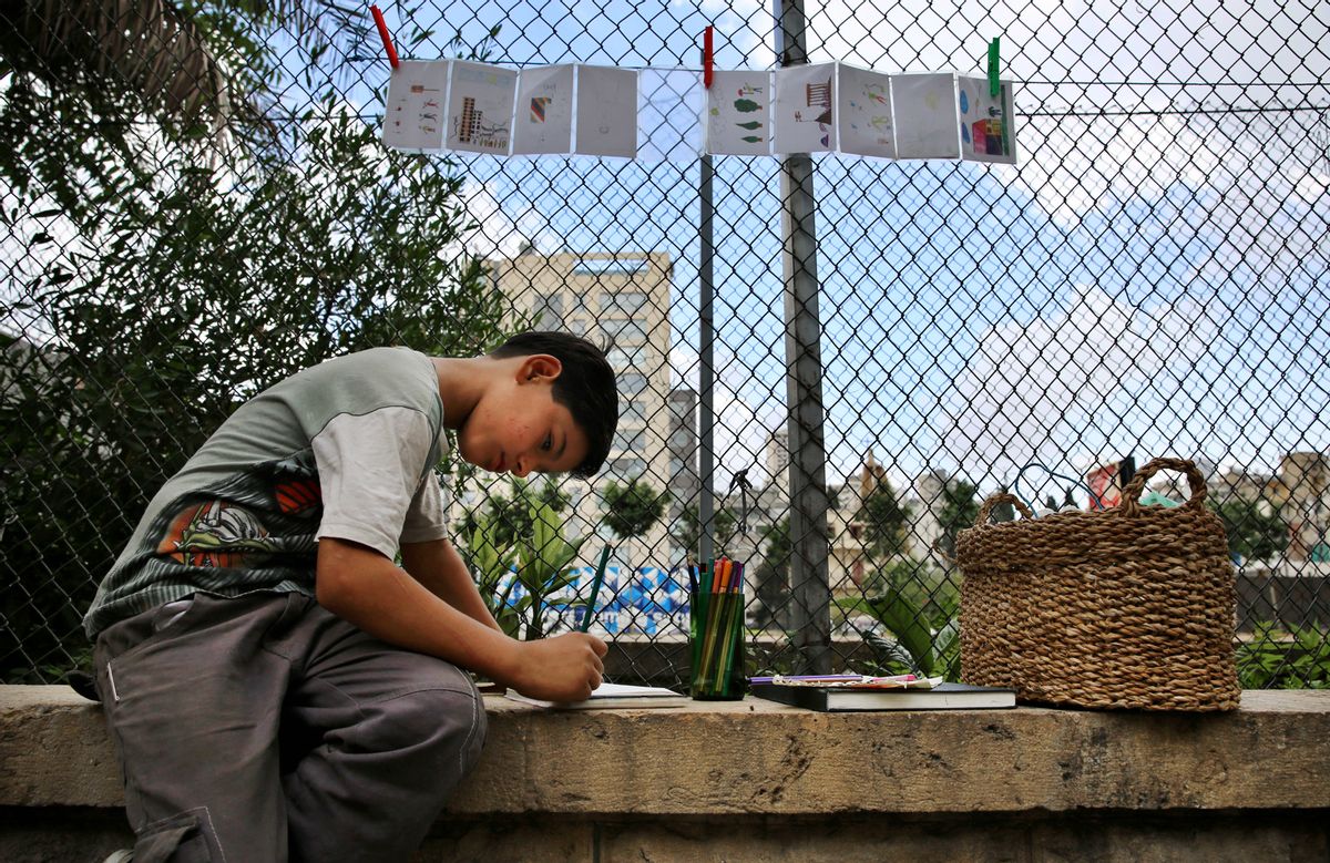 In this Saturday, May 28, 2016 photo, Syrian refugee Mohammed Ali Darwish draws on cards that he later sells in Beirut, Lebanon. More than 1.1 million Syrians have sought refuge here since the start of the 2011 uprising, more than half of them children. The U.N.'s children agency, UNICEF, says there are 2.8 million children out of school in the region, and child refugees are particularly at risk of exploitation and abuse, with large numbers having no choice but to go to work. (AP Photo/Bilal Hussein) (AP)