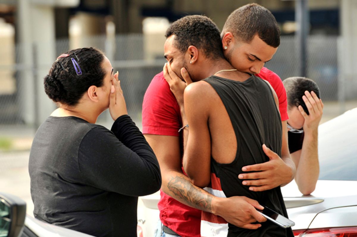 Friends and family members embrace outside the Orlando Police Headquarters during the investigation of a shooting at the Pulse night club, Orlando, Florida, June 12, 2016.    (Reuters/Steve Nesius)