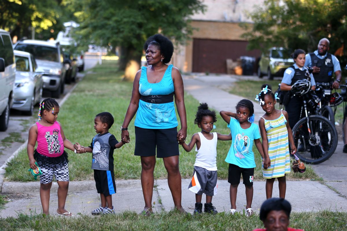 In this July 5, 2016 photo, Ruby Mack, stands with 5 of her grandchildren as Englewood neighborhood residents gather for a meeting with Chicago police on the South Side of Chicago. The meeting was set up in response to two children, ages 4 and 6, being shot on the 4th of July 2016. With a spike in killings and shootings this year in Chicago, statistics show more bullets are hitting children as they do normal kid things like play with sparklers, draw on the sidewalk or hold a mother’s hand. () (Chris Sweda/Chicago Tribune via AP)