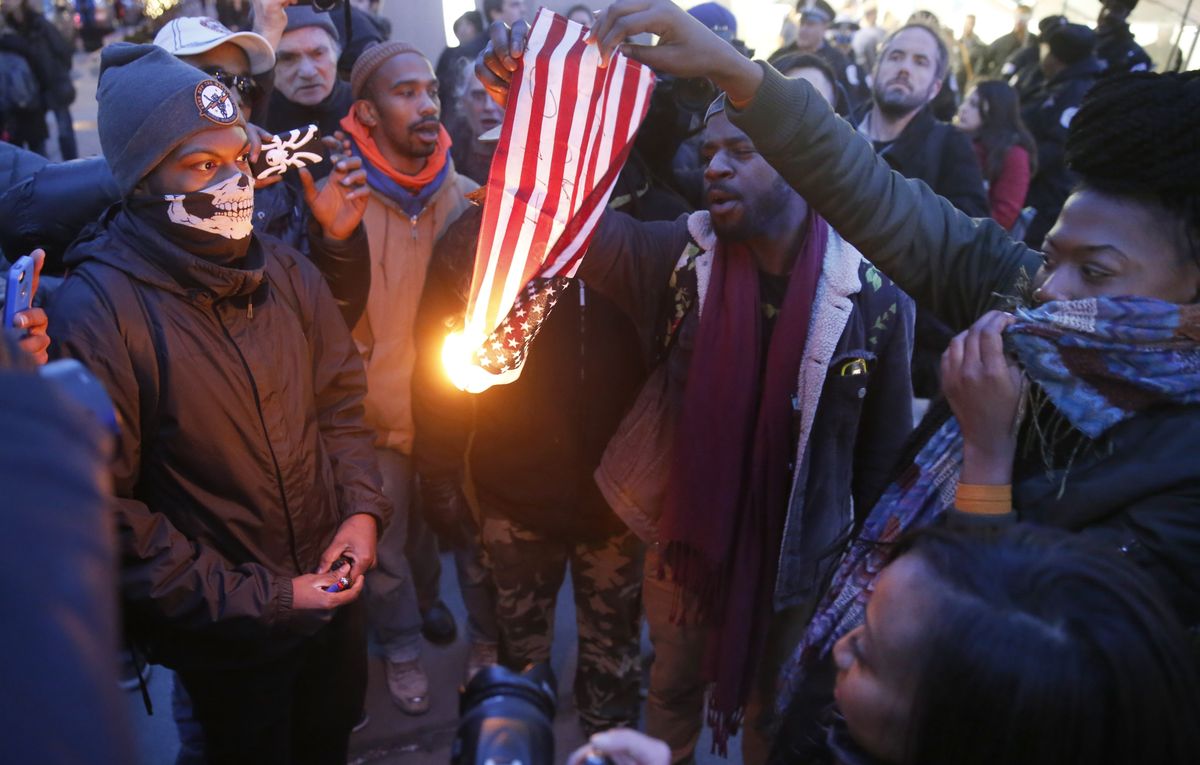 FILE - In this Feb. 23, 2016 file photo, protesters burn an American flag in Chicago. Champaign County Ill. (AP)