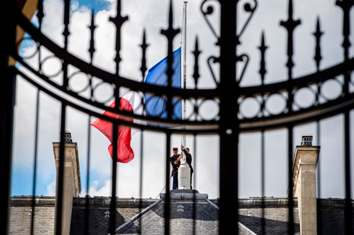 A Republican Guard lowers the French national flag to half-mast at the Elysee Palace in Paris, France, July 15, 2016.   (Reuters/Christophe Petit Tesson)