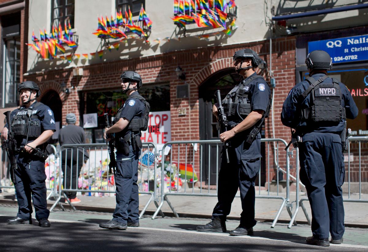 FILE - In this June 14, 2016 file photo, armed police officers stand guard outside the historic Stonewall Inn in New York as people congregate to pay their respects for the the victims and survivors of the Orlando nightclub shooting. The officers are heavily armed and equipped, in a manner typical of the NYPD's counterterrorism unit and Emergency Service Unit - the NYPD's equivalent of SWAT officers. But the NYPD plans to distribute 20,000 helmets and 6,000 vests before the end of the year to uniformed patrol officers to protect them better during combat with rampaging shooters (AP Photo/Mary Altaffer, File) (AP)