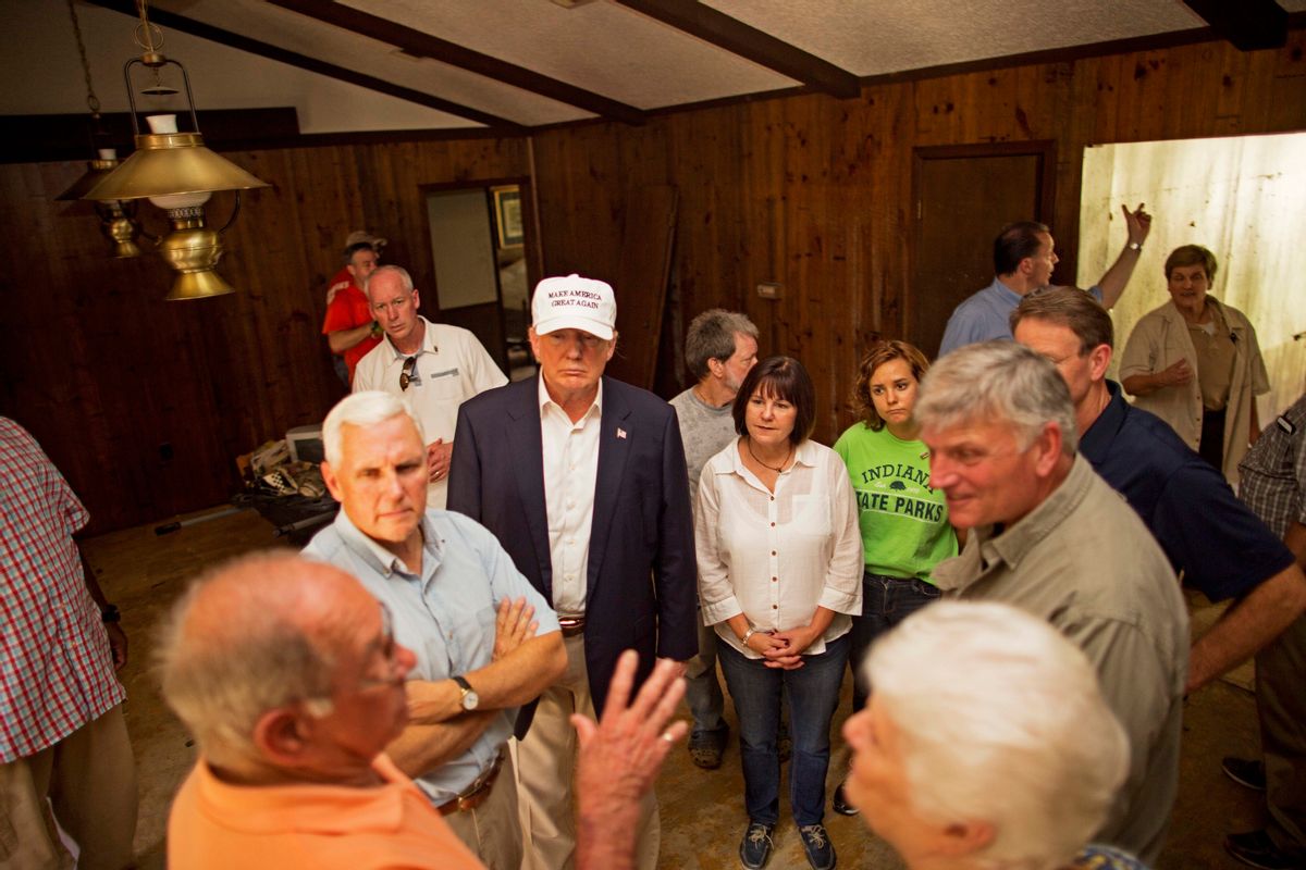 Republican presidential candidate Donald Trump, center, and his running mate, Indiana Gov. Mike Pence, listens to flood victims Jimmy and Olive Gordan during a tour of their flood damaged home in Denham Springs, La.,  (AP)