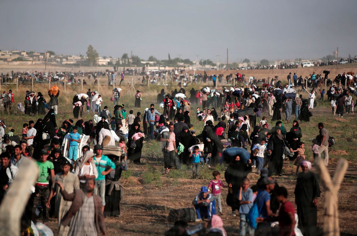 FILE - In this June 14, 2015 file photo taken from the Turkish side of the border between Turkey and Syria, in Akcakale, Sanliurfa province, southeastern Turkey, thousands of Syrian refugees walk in order to cross into Turkey. After a slow start, it appears increasingly likely that the Obama administration will hit its goal of admitting 10,000 Syrian refugees into the United States before the end of September. (AP Photo/Lefteris Pitarakis, File) (AP)