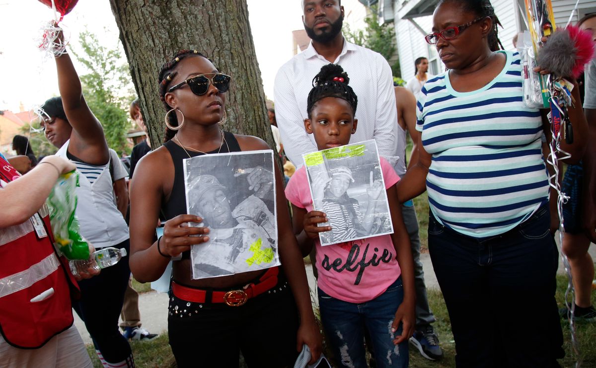 Family members of Sylville Smith gather where he was shot and killed by Milwaukee police in Milwaukee, Sunday, Aug. 14, 2016. Police in Milwaukee say a black man whose killing by police touched off arson and rock-throwing was shot by a black officer after turning toward him with a gun in his hand. Wisconsin's governor, meanwhile, has put the National Guard on standby in case of more violence Sunday night. (AP Photo/Jeffrey Phelps) (AP)