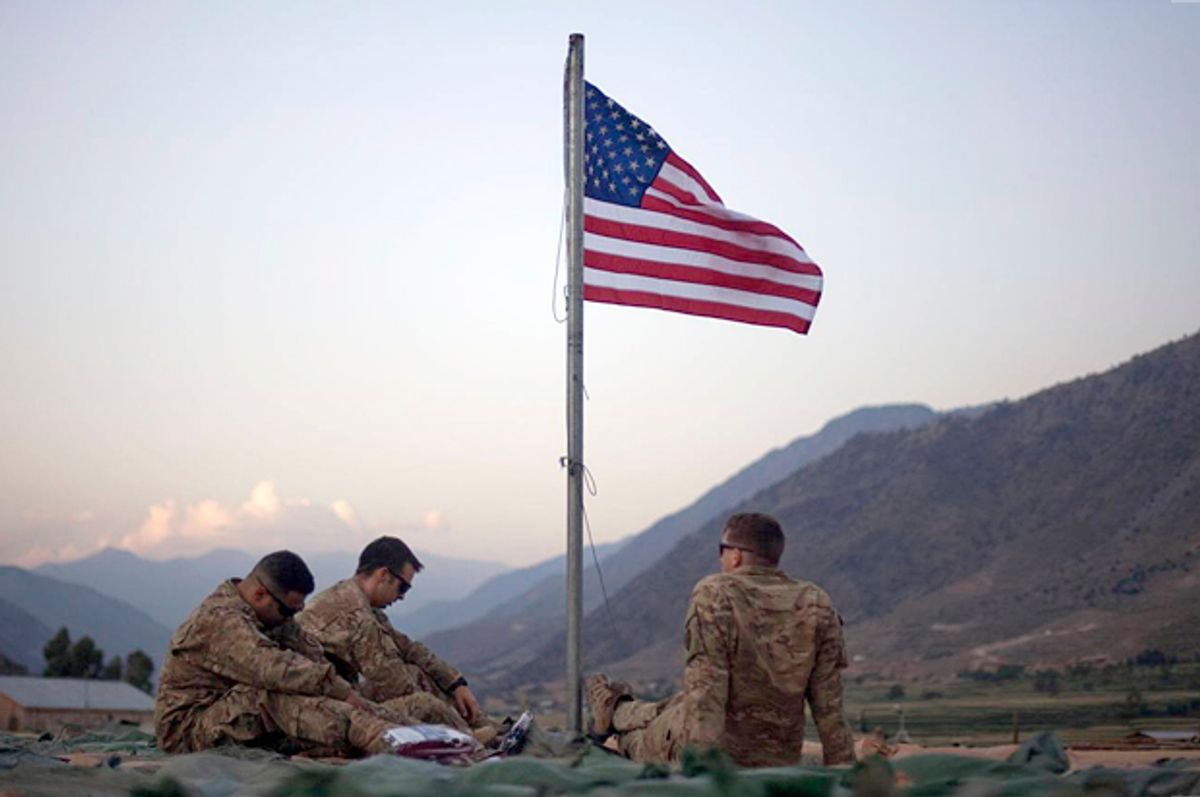 Spc. Angel Batista, 26, left to right, of Bloomingdale, N.J., Spc. Jacob Greene, 22, of Shreveport, La., and Sgt. Joe Altmann, 26, of Marshfield, Wisc., with the U.S. Army's 25th Infantry Division, 3rd Brigade Combat Team, 2nd Battalion 27th Infantry Regiment based in Schofield Barracks, Hawaii, sit beneath a new American flag just raised to commemorate the tenth anniversary of the 9/11 attacks Sept. 11, 2011 at Forward Operating Base Bostick in Kunar province, Afghanistan. (AP Photo/David Goldman) (AP/David Goldman)