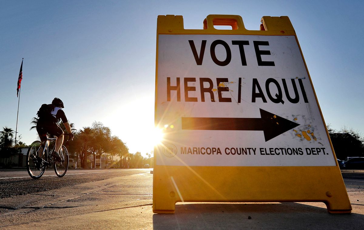 FILE - In this Aug. 30, 2016 file photo, a cyclist rides past a sign directing voters to a primary election voting station early, in Phoenix. Early voting kicks off next week in North Carolina, the first in a two-month run of voting through key swing states where non-whites and young adults could give one of the presidential campaigns a decisive advantage before Election Day.   (AP Photo/Matt York, File) (AP Photo/Matt York, File)