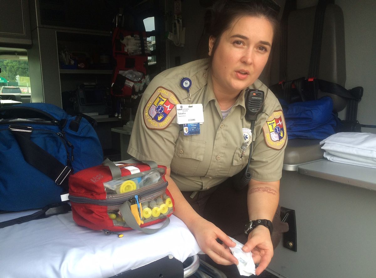 In this Aug. 28, 2016 photo, Cabell County EMT Tabitha Perez demonstrates how medics administer naloxone to overdosing patients, in Huntington, W.Va. On Aug. 15, 28 people overdosed in Huntington and 26 survived. Without the life-saving drug, authorities suspect the death toll would have been much higher. The laced heroin was so potent, the typical dose failed to revive many of them. They used two, sometimes three doses to bring them back to life. (AP Photo/Claire Galofaro) (AP)