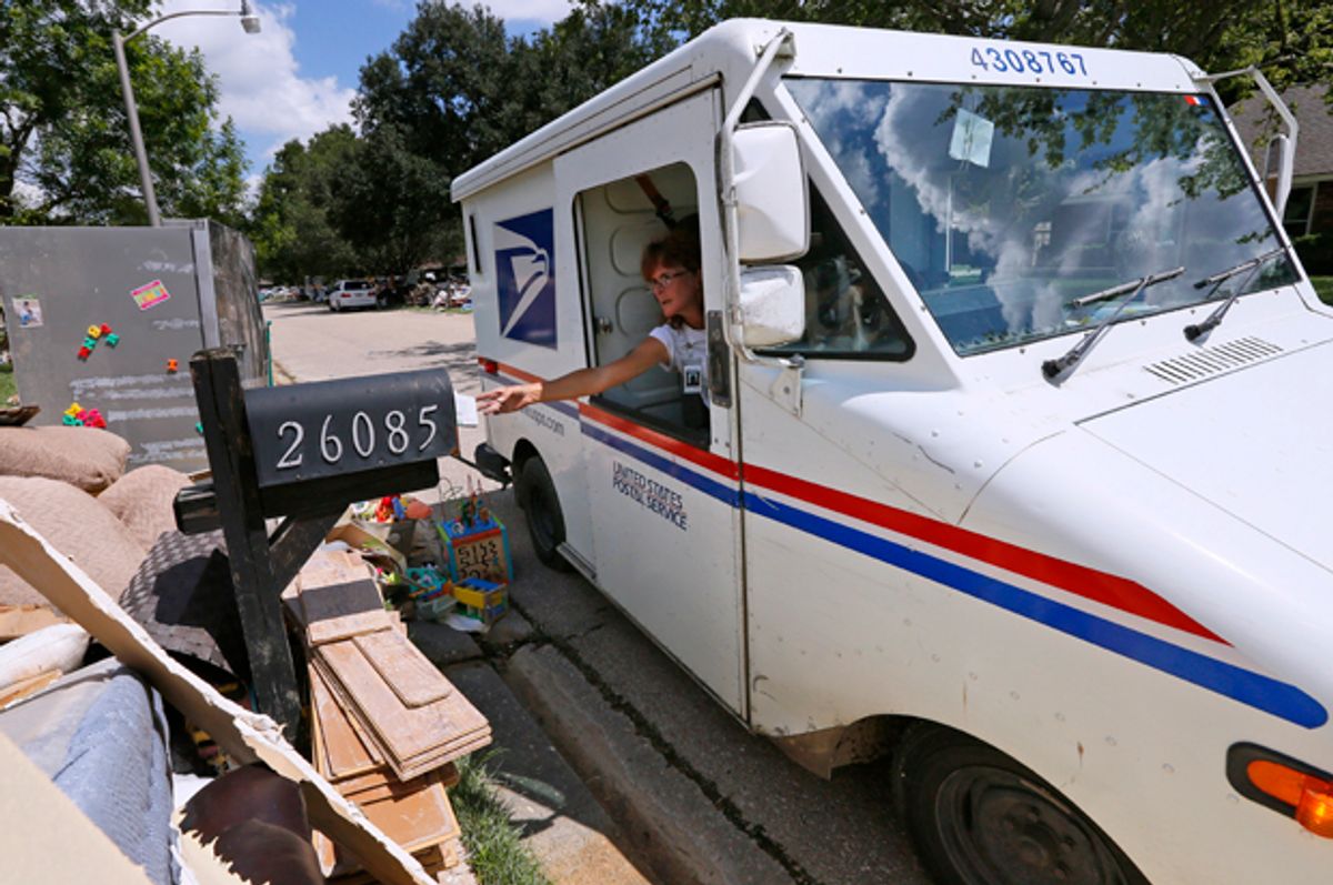 A United States Postal Service worker delivers mail to a flood damaged neighborhood in Denham Springs, Louisiana, August 23, 2016.   (Reuters/Jonathan Bachman)