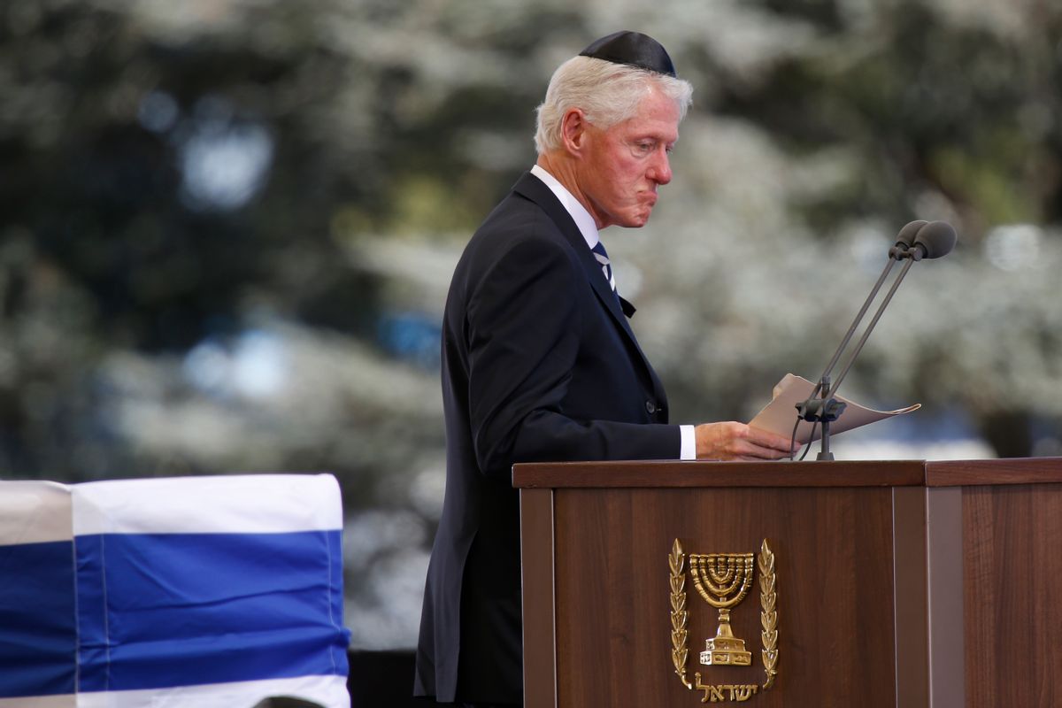 Former US President Bill Clinton passes the flag-draped coffin of former Israeli President Shimon Peres during his funeral at the Mount Herzel national cemetery in Jerusalem, Friday, Sept. 30, 2016. (AP Photo/Ariel Schalit) (AP)