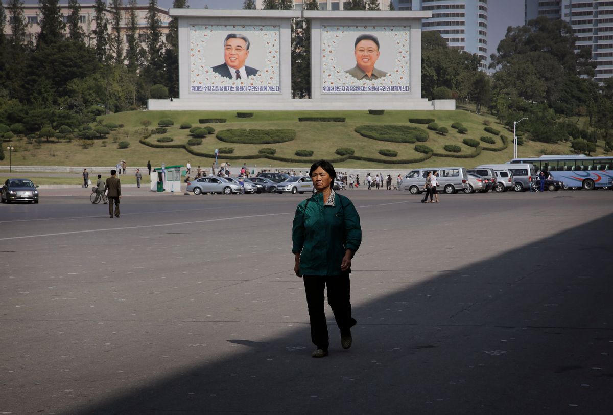 In this Friday, Sept. 23, 2016, photo, a North Korean woman walks down the street where murals of the late North Korean leaders Kim Il Sung, left, and Kim Jong Il decorate the streets in downtown Pyongyang, North Korea.  (AP)