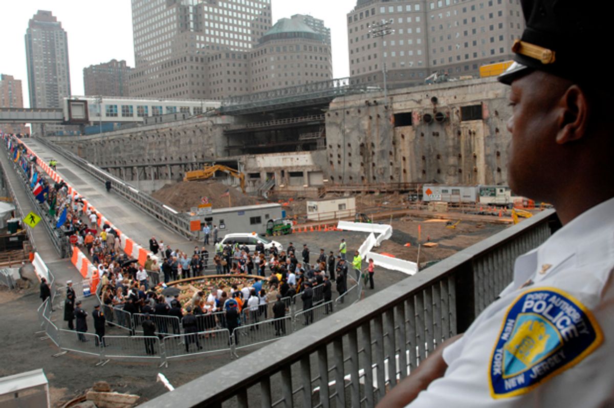 A Port Authority police officer watches the ceremony as victims' families walk down the ramp to place flowers in the reflecting pool during the ceremony on Sept. 11, 2007.   (AP/Susan Watts)