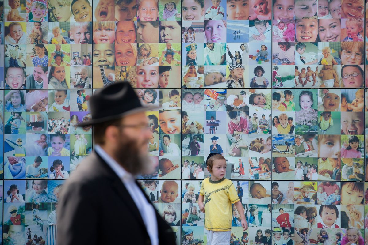 An Orthodox Jewish child walks alongside a collage wall at the Jewish Children's Museum, Monday, Aug. 11, 2014, in the Brooklyn borough of New York. The museum is the largest Jewish-themed children's museum in the United States. (AP Photo/John Minchillo) (AP)
