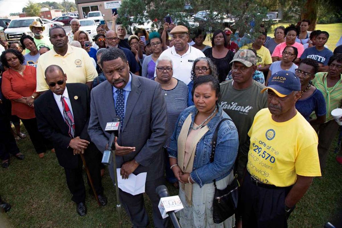 Derrick Johnson, left, president of the Mississippi NAACP, center left, talks to the media on behalf of Stacey Payton, center right, and Hollis Payton, behind his wife Stacey, in front of the Stone County Courthouse in Wiggins, Miss., Monday, Oct. 24, 2016. Johnson is demanding a federal investigation after the parents said four white students put a noose around their son's neck at school. (Max Becherer, AP)