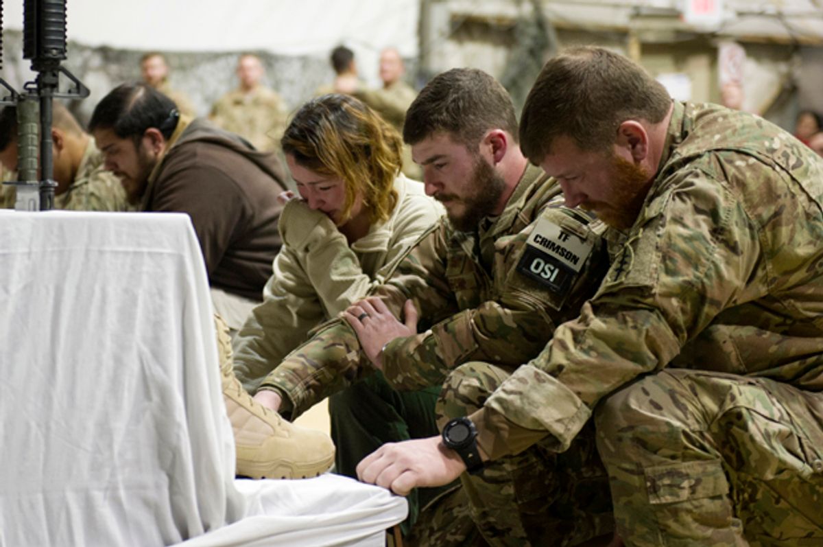 U.S. service members pay their respects during a memorial ceremony for six Airmen killed in a suicide attack, at Bagram Air Field, Afghanistan   (AP/Tech. Sgt. Robert Cloys)