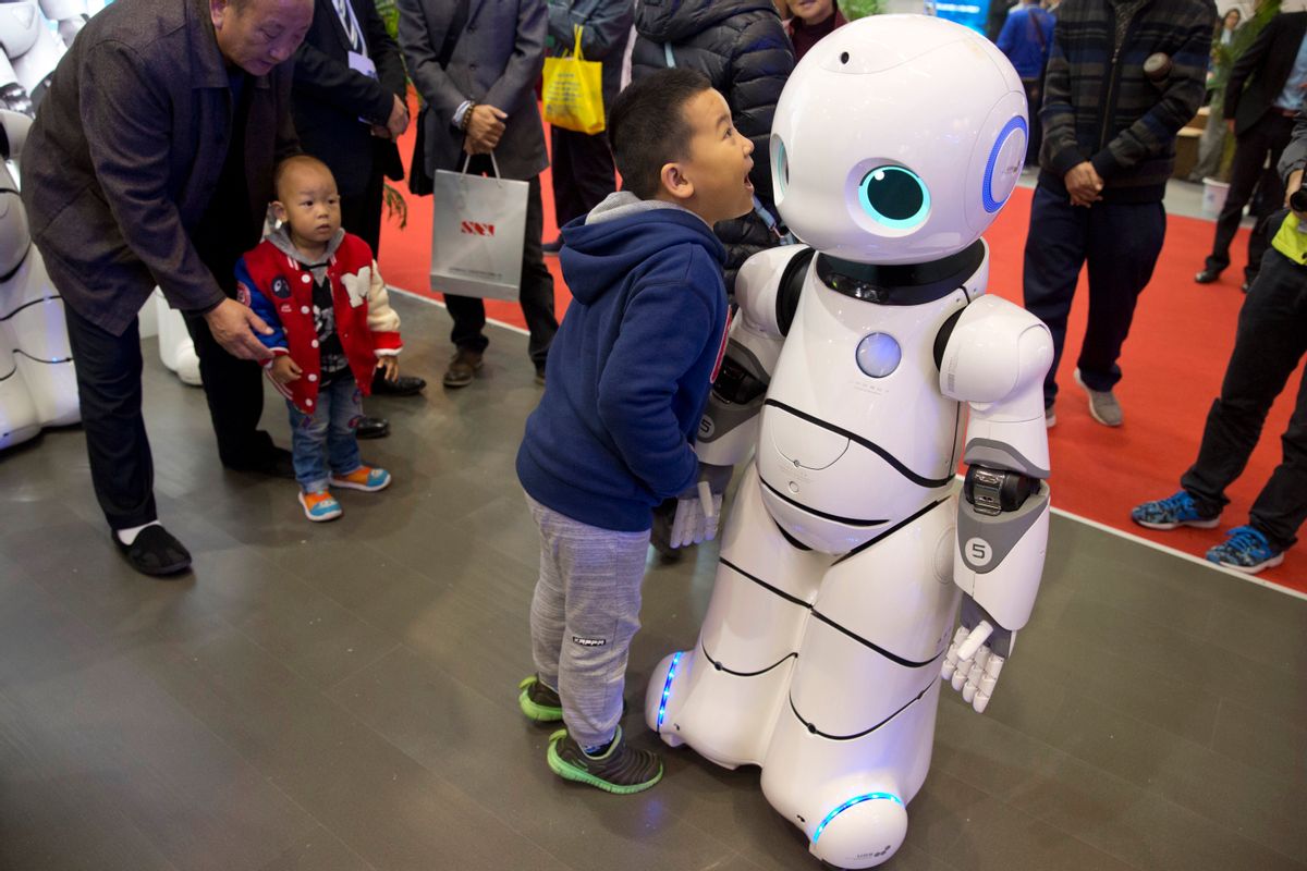 In this Friday, Oct. 21, 2016 photo, a Chinese boy shouts into the Canbot, a companion robot, displayed during the World Robot Conference in Beijing, China. China is showcasing its burgeoning robot industry as it seeks to promote use of more advanced technologies in Chinese factories and create high-end products that redefine the meaning of “Made in China.” The Canbot can dance and respond to voice commands, while others can play badminton, sand cell phone cases and sort computer chips. (AP Photo/Ng Han Guan) (AP)