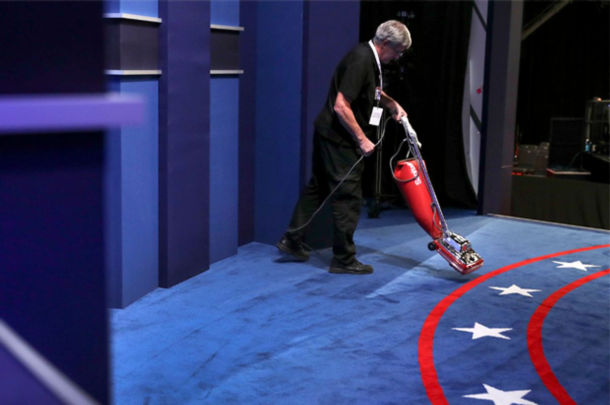 A stage hand vacuums the carpet before the third and final debate   (AP/Joe Raedle)