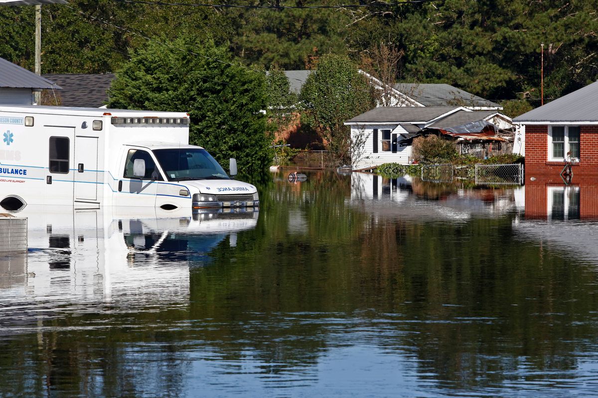 Floodwaters associated with Hurricane Matthew surround homes and an ambulance on Thursday, Oct. 13, 2016, in Lumberton, N.C.  Gov. Pat McCrory said Thursday the number of power outages was down to about 55,000, from a high of nearly 900,000 when the storm hit. (AP Photo/Brian Blanco) (AP)