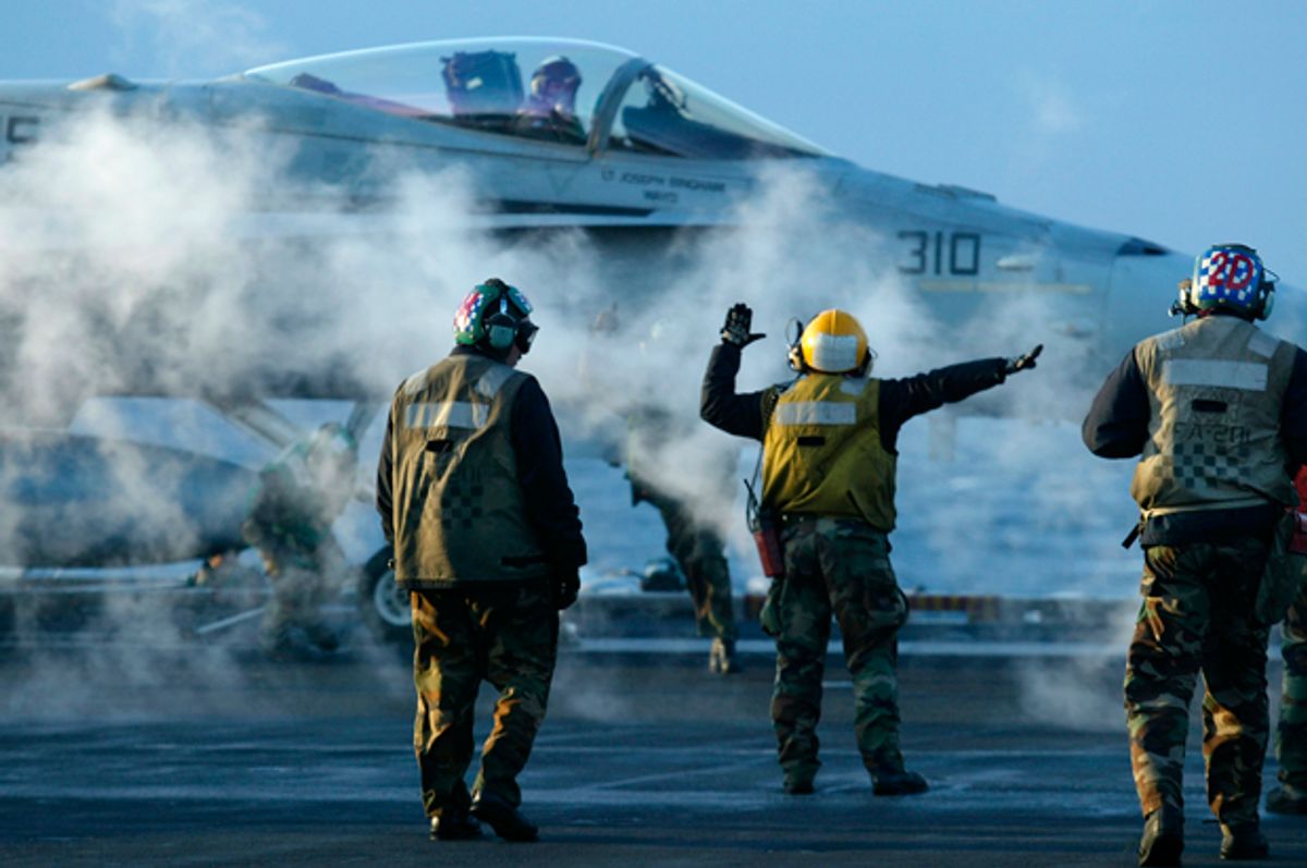 Flight deck crew prepare to launch an F/A 18 Hornet during early morning flight operations from the USS Theodore Roosevelt, Thursday March 20, 2003.   (AP/Richard Vogel)